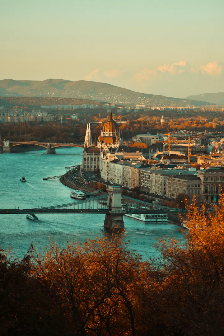 A panoramic view of Budapest buildings, water and bridge.