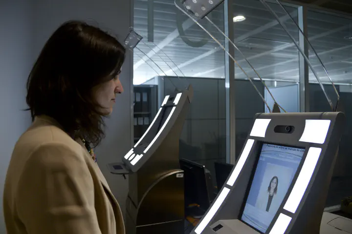 Europe Travel. A woman in front of a kiosk at an airport.